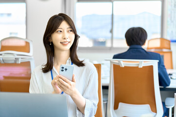 携帯電話を使う女性　ビジネスシーン　オフイス