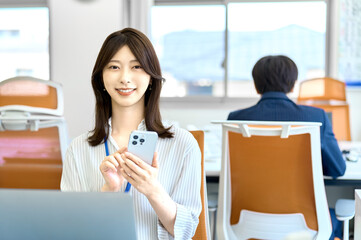 スマホを使うビジネスウーマン　会社　オフィス　女性
