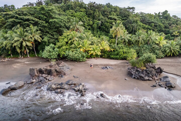 Tourists walking on remote beach in nuqui, choco, colombia, aerial view
