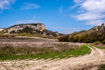 A dirt road among the hills on a summer day.