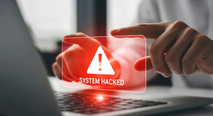 A persons finger points to a digital alert on a screen indicating a system hack, highlighting cybersecurity threats