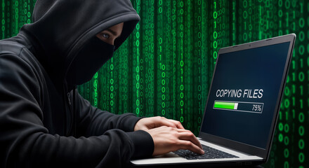 A hooded figure wearing a mask types on a laptop, with a progress bar indicating file copying amidst a backdrop of green binary code, symbolizing cybercrime and data transfer