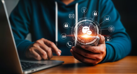 A person uses a smartphone with a glowing digital interface displaying chat icons and various service icons, connected to a laptop, symbolizing modern communication and technology