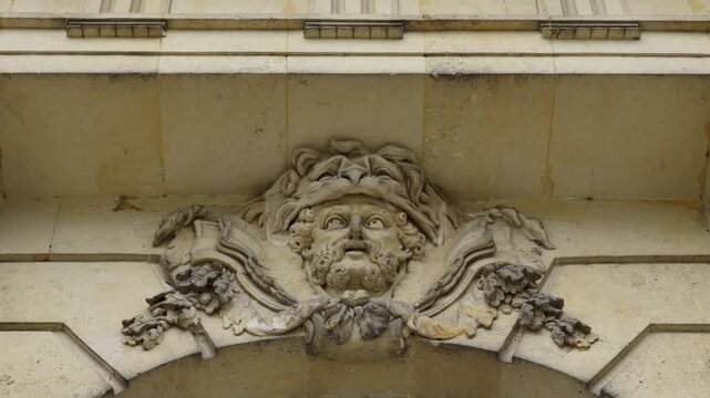 Mascaron adorning building facade, architectural detail. Action
