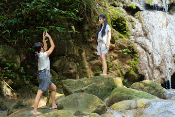 Asian Indonesian Woman Taking Travel Photo at Waterfall in Yogyakarta