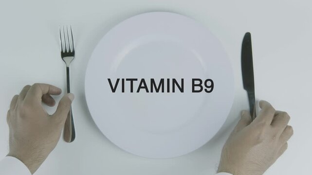 Vitamin B9 word on a plate with hands holding fork and knife on white background, symbolizing nutrition, healthy eating, dietary supplements, and wellness concept illustration