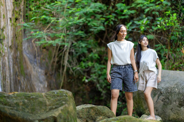 Asian Indonesian Women Trekking Barefoot by River Rocks in Yogyakarta Jungle