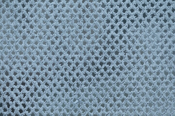 This image features a detailed closeup of a white mesh fabric that showcases numerous holes punctuating its surface, creating a unique texture
