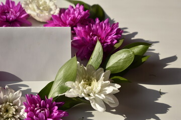 white card among colorful flowers, mockup. Empty space for text