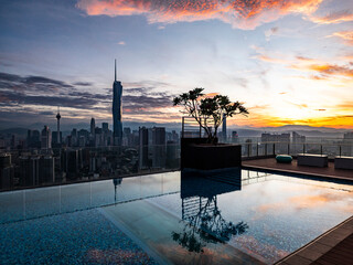 Luxury rooftop infinity pool at sunrise over Kuala Lumpur financial district
