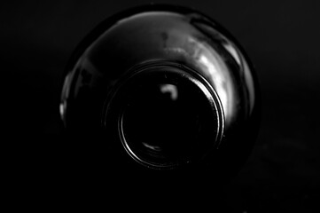 Boca de una botella de vino tumbada con fondo oscuro