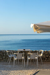 Cozy seaside terrace by a stone wall overlooking the calm blue sea, perfect for relaxing moments and enjoying ocean views on a sunny day.