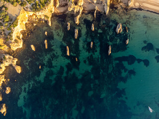 Aerial view of Praia do Alemão beach in Portimão, Algarve, Portugal, during a sunny morning with clear blue waters and golden sandy shore. Perfect for travel and nature themes.