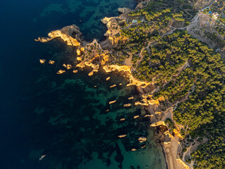Aerial view of Praia do Alemão beach in Portimão, Algarve, Portugal, during a sunny morning with clear blue waters and golden sandy shore. Perfect for travel and nature themes.
