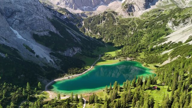 Aerial drone view of the Alps and the green Seebensee on a sunny summer day. A couple enjoys the view of Seebensee and goes hiking. Seebenlake 