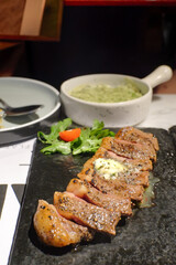 Exquisite Medium-Rare Sliced Steak with Butter and Fresh Salad served on Dark Plate A Delightful Culinary Experience Savor Every Bite of Perfectly Cooked Steak, a Feast for the Senses