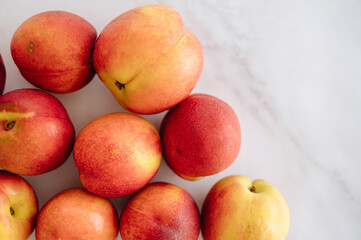 Fresh, ripe nectarines artfully arranged on a clean white table