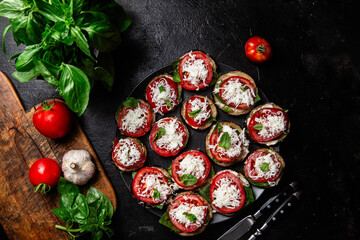 Appetizing appetizer of eggplants, tomatoes and basil in a plate on the table