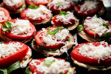Appetizing appetizer of eggplants, tomatoes and basil in a plate on the table