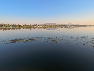 Panoramic landscape view across nile river to luxor west bank with mountains and reflection
