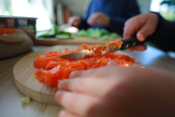 two child's hands cutting vegetables for salad close up