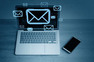Digital email communication concept with envelope icons displayed on laptop screen and floating...