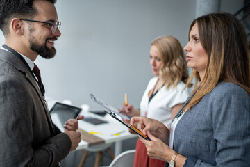 Business people discussing using digital tablet and clipboard in office