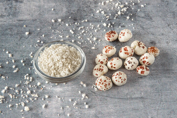 Close-up of a puffed lotus seed, makhana, and powder, an exotic plant ingredient