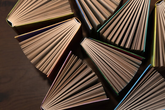 Hardcover books, colored covers textbooks, top view, on wooden floor. Books and reading are necessary for self-improvement, gaining knowledge and success in career, business and personal life.