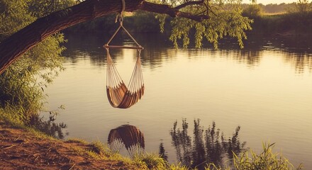 Tranquil river scene with hammock hanging from tree branch at sunset creating peace