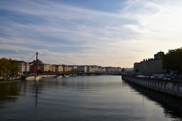 Historic cityscape of Old Town (Vieux Lyon) and the Saône River at dusk, featuring the red Passerelle Saint-Georges footbridge in Lyon, France, a UNESCO World Heritage Site