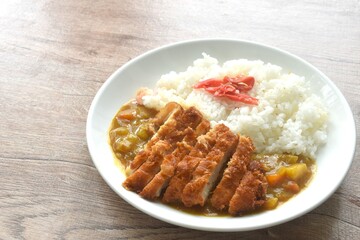 Tonkatsu crispy fried pork slice topping plain rice dressing potato and carrot in Japanese curry on plate 