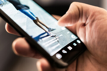 Short viral video on social media. Trend reel content in phone screen. App and platform for clips, live streaming or promotion campaign. Watching digital entertainment online. Man with smartphone.