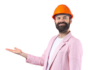 Portrait of young construction engineer wear orange hard hat, in a pink jacket standing on red studio background. The man points with his hand.