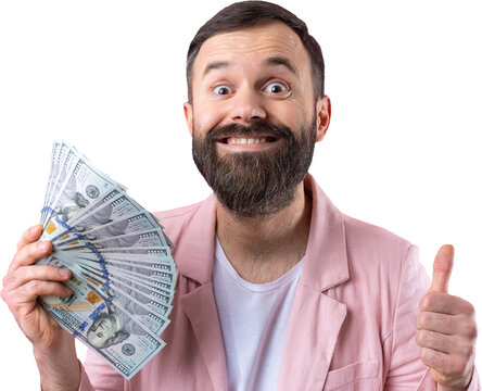 Portrait of a contented young businessman with a beard dressed in a pink jacket showing us dollar banknotes against a red studio background. Taste, smell of money.