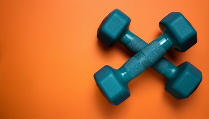 Pair of teal dumbbells isolated on orange background with copy space for text, fitness, sport, gym, exercise equipment, barbells, weights for health and strength, training