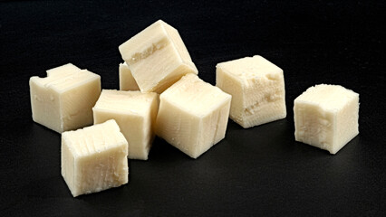 Cubes of white cheese isolated on black background