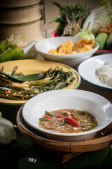 Shrimp paste chili dip, steamed rice, stir-fried morning glory with chili paste and omelet are placed on the dining table. Retro Thai style image.