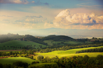 Rolling green hills of Tuscany under cinematic light and pastel summer clouds