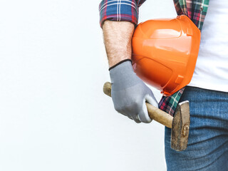 Handsome man in work clothes and hardhat. Labor day. Close-up, indoors. Studio shot. Front view,...