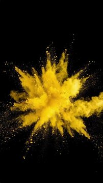 Energetic explosion of vibrant golden yellow pigment with particles against a contrasting black background for artistic creativity and abstract art
