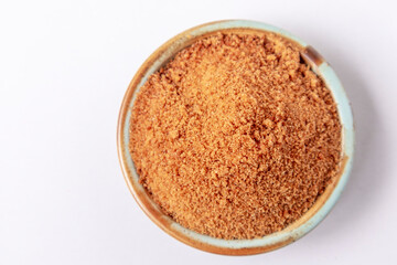 Top view of palm sugar in a bowl isolated on white. brown coconut palm sugar.
