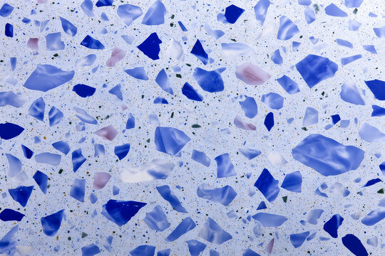 A close-up view of a speckled mosaic stone pattern, with an array of blue and purple shapes embedded within a light surface - Powered by Adobe