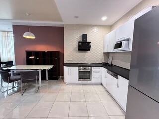 Contemporary kitchen with built-in appliances and dining area