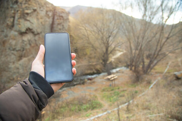 Male hand showing smartphone in nature. No signal