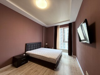 Cozy modern bedroom with large window and hardwood floor