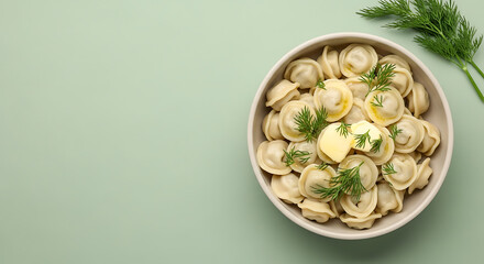 Dumplings with Butter and Dill in Bowl on Pastel Green Background