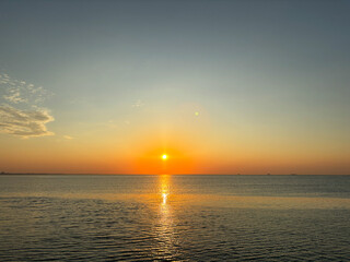 Оrange sunrise or sunset on the beach with wave