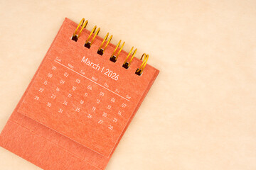 Mini red desk calendar for March 2026 year on old brown paper background, Flat lay.