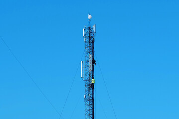 Maintenance staff at the work. High-altitude work. Worker repair cell tower